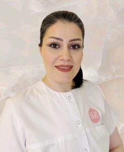 Die Mitarbeiterin der Adler Kosmetik Nafise Zarei in einem weißen Mantel.